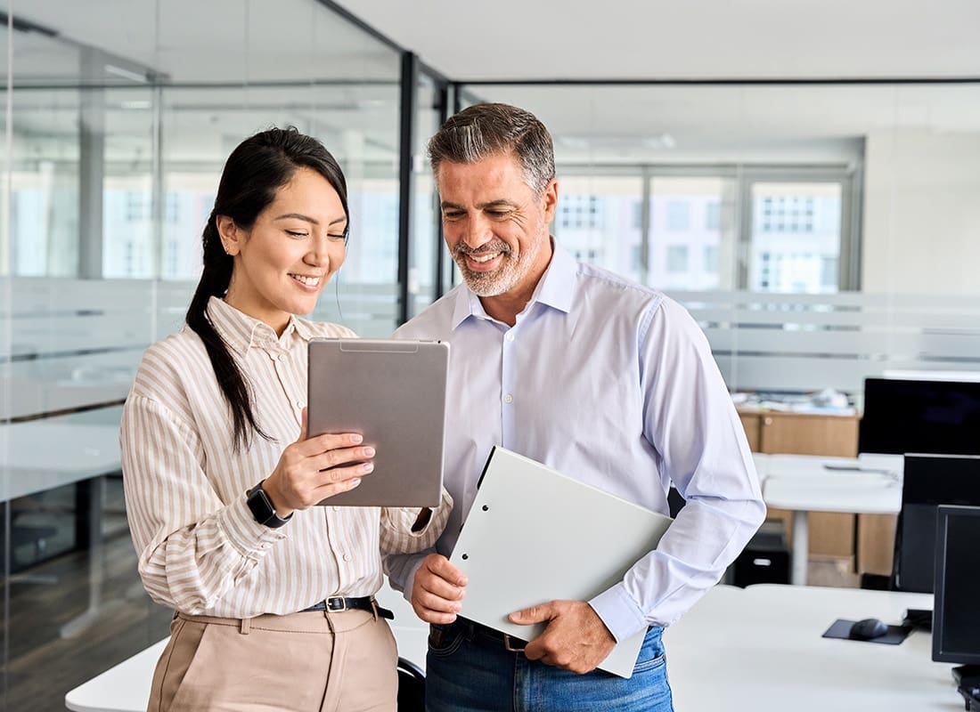 Contact - Two Business Professionals Looking at Documents in an Office