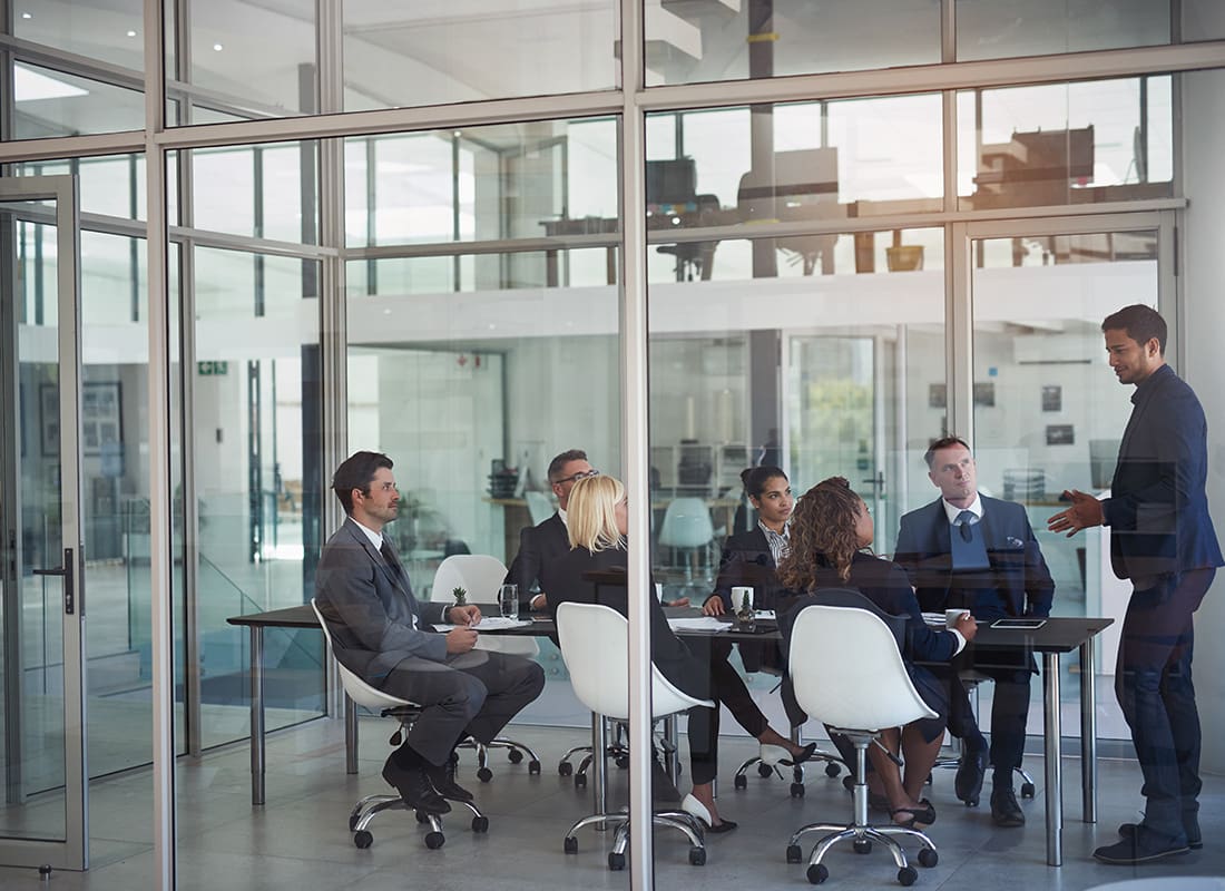 Laurel, MS - Group of Professionals Having a Meeting in an Office With Glass Walls